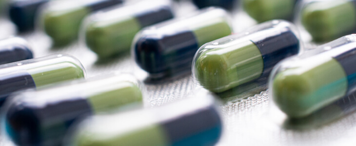 Green and blue pills coming off of a pharmaceutical factory production line