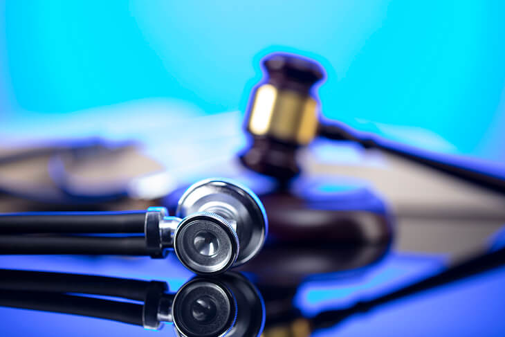 gavel and stethoscope against blue background